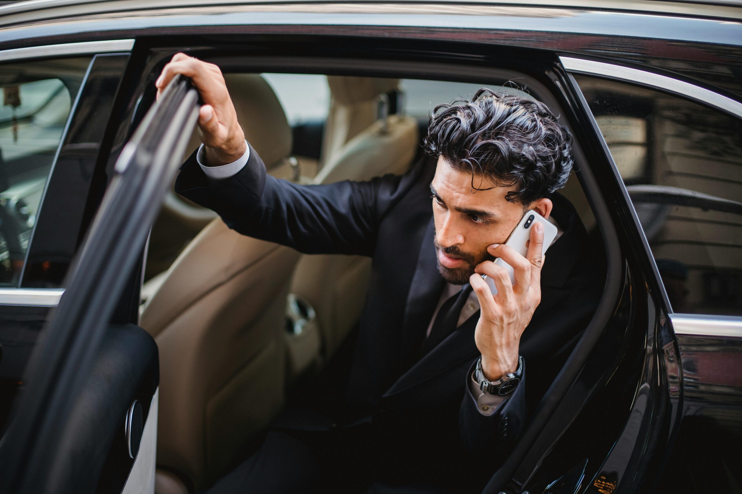 California rideshare accident lawyer making a call while exiting car.