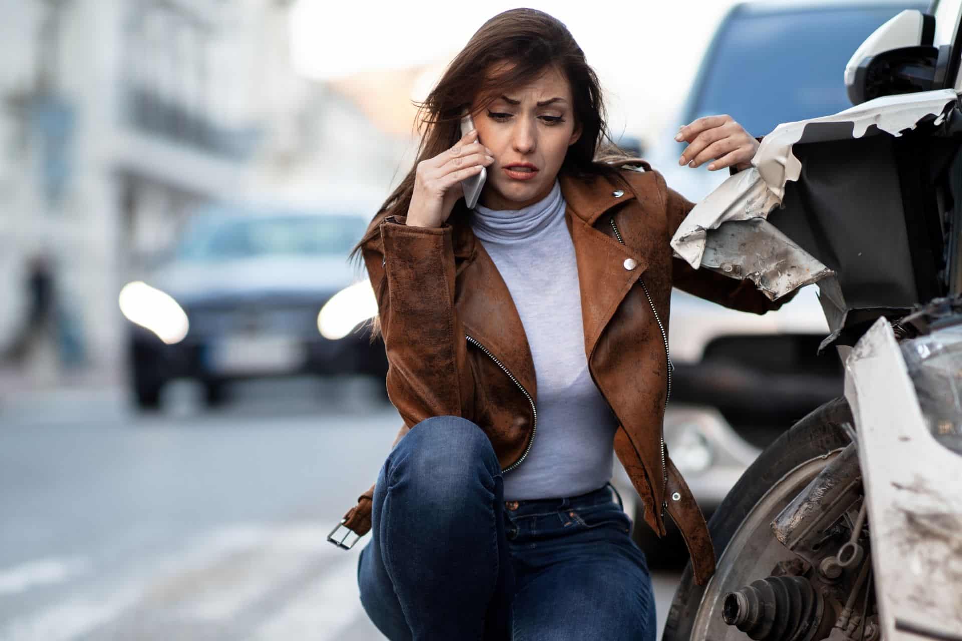 Injured driver calling for assistance next to a damaged vehicle after a collision, illustrating a Sacramento car accident case and insurance claim process.