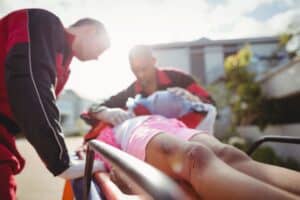 Paramedics providing emergency oxygen to an injured girl, a common scenario in severe San Diego accident and head injury cases.