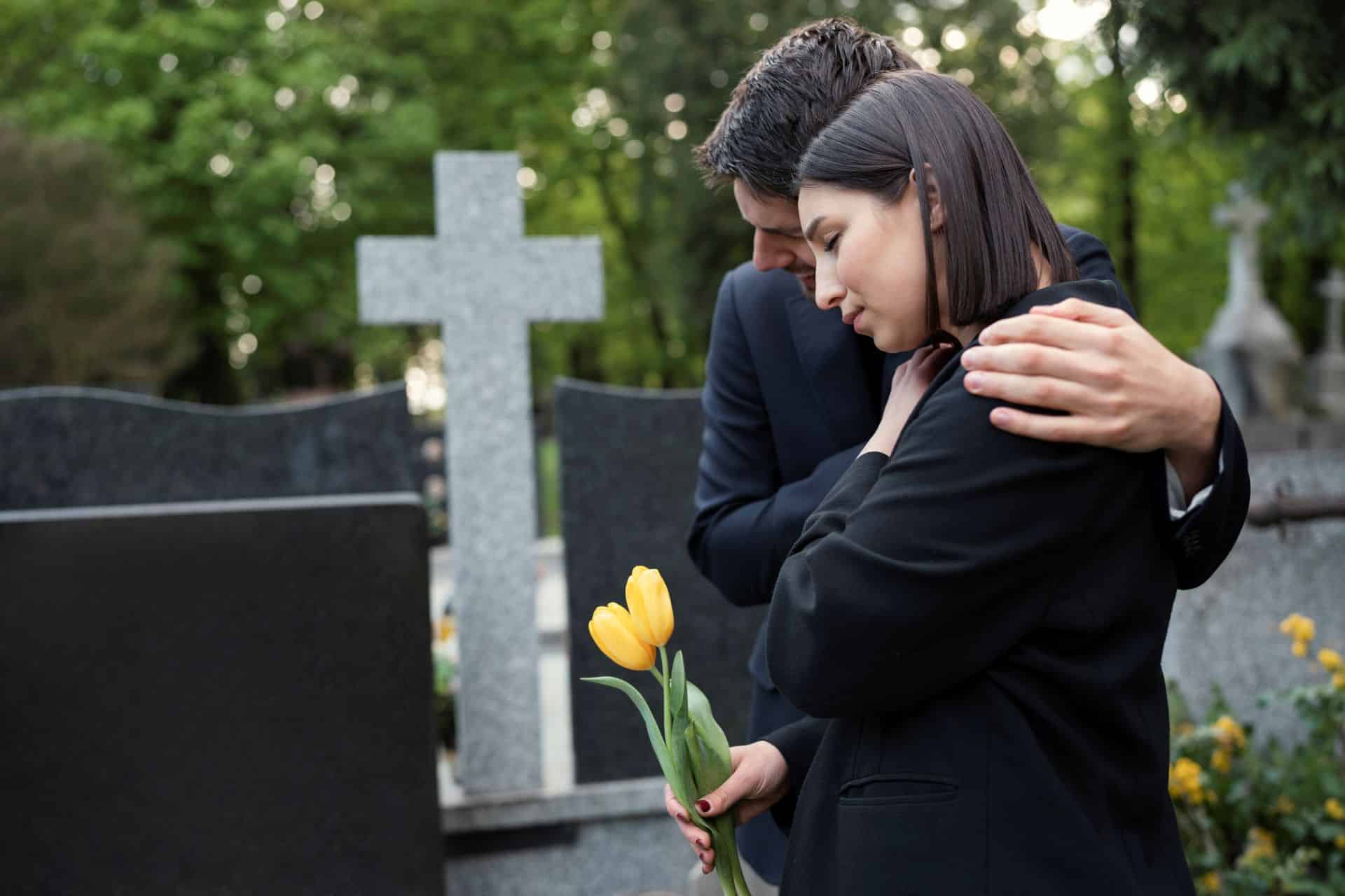 Bereaved family visiting a gravesite after the loss of a loved one, illustrating a wrongful death lawsuit and compensation claim in California.