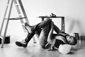 Man holding his knee on the ground after a fall accident, a common scenario in San Diego slip and fall premises liability claims.