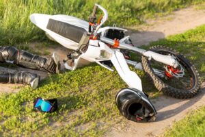 Damaged motorcycle at an accident scene with riding gear scattered on the ground, illustrating an Anaheim motorcycle accident and rider injury case.