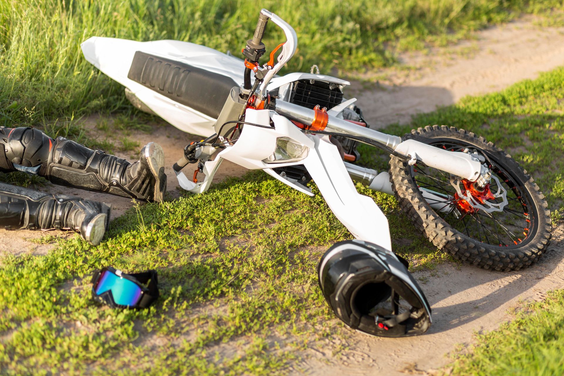 Damaged motorcycle at an accident scene with riding gear scattered on the ground, illustrating an Anaheim motorcycle accident and rider injury case.