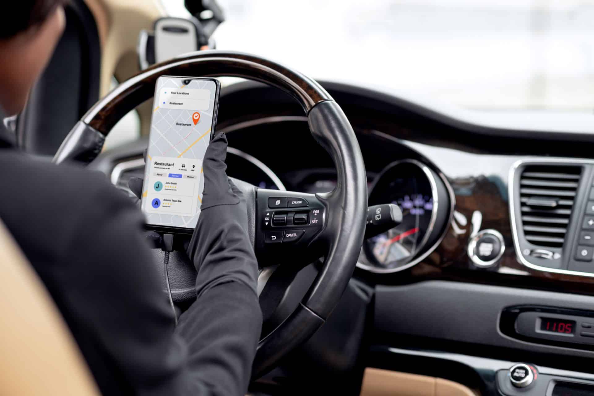 Rideshare driver using a navigation app while operating a vehicle, representing a Lyft trip and a potential Sacramento Lyft accident claim where app status may affect insurance coverage.