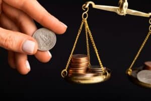 Scales of justice balancing coins and money, representing car accident settlement value, compensation, and personal injury claims in Ontario, California.
