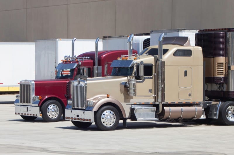 Large semi-trucks at a logistics yard, illustrating a commercial trucking accident case handled by a Bakersfield big rig accident lawyer.