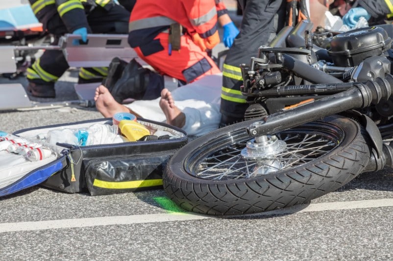 Emergency personnel treating a motorcyclist after a traffic collision, representing a motorcycle accident case handled by a Bakersfield motorcycle accident lawyer.