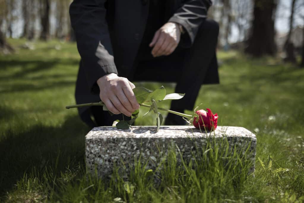 Two wooden figures balanced on a seesaw representing fault, liability, and wrongful death claims after a fatal car accident.