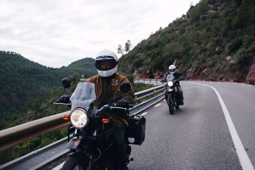 Motorcyclist riding a Riverside County highway with the Box Springs hills behind