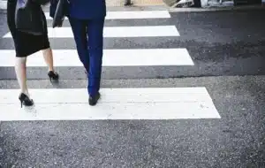 Marked crosswalk at a Fresno intersection with a pedestrian signal showing a walk phase